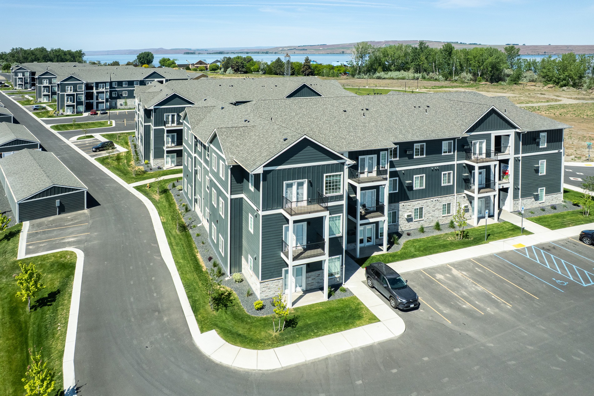 A large grey building with a parking lot in front.